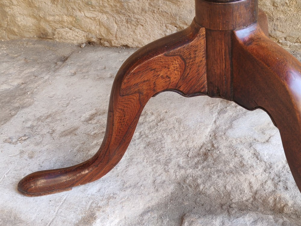 An 18th-century Georgian oak tripod table featuring a circular tilt-top surface positioned vertically on a turned baluster column and three curved legs. View V