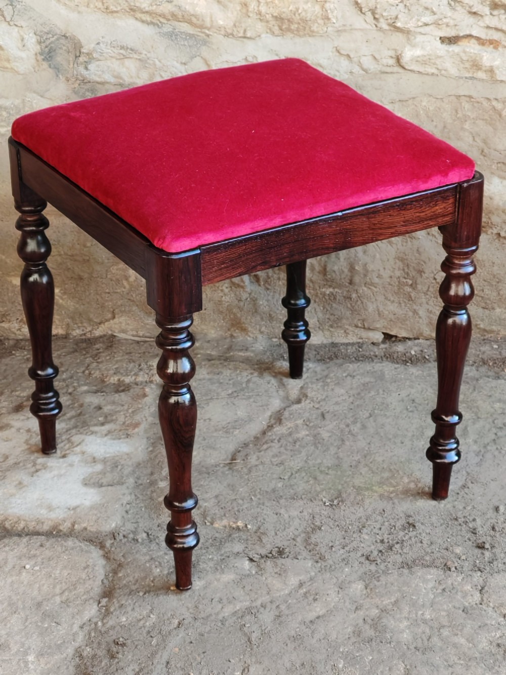 An antique square rosewood stool featuring turned legs and a red velvet upholstered seat. View V
