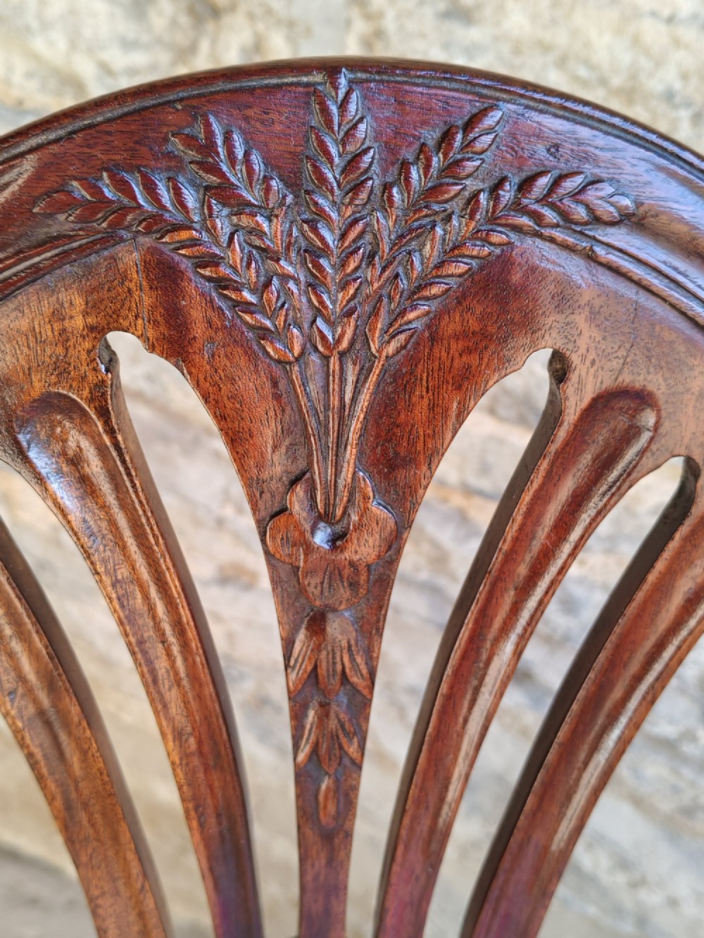 A set of four antique mahogany Hepplewhite dining chairs featuring carved shield-shaped backs with central inlay motifs and light green upholstered seats. View V