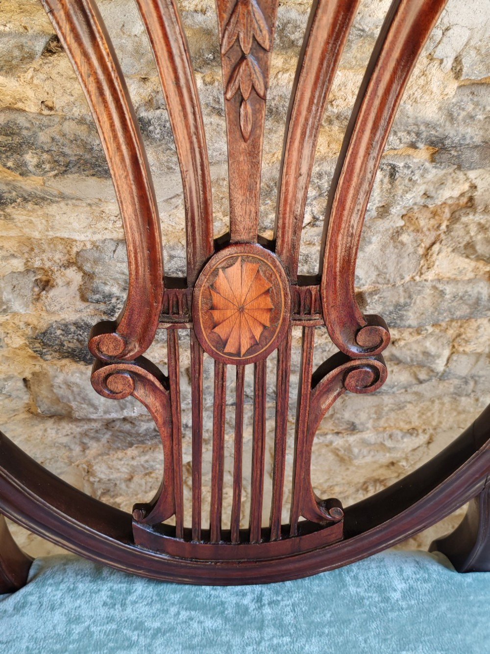 A set of four antique mahogany Hepplewhite dining chairs featuring carved shield-shaped backs with central inlay motifs and light green upholstered seats. View VI
