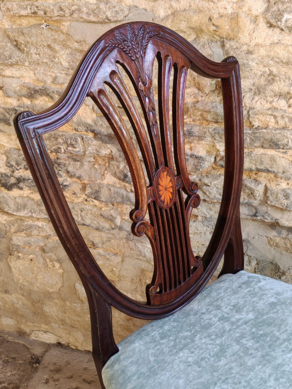 A set of four antique mahogany Hepplewhite dining chairs featuring carved shield-shaped backs with central inlay motifs and light green upholstered seats. View VII