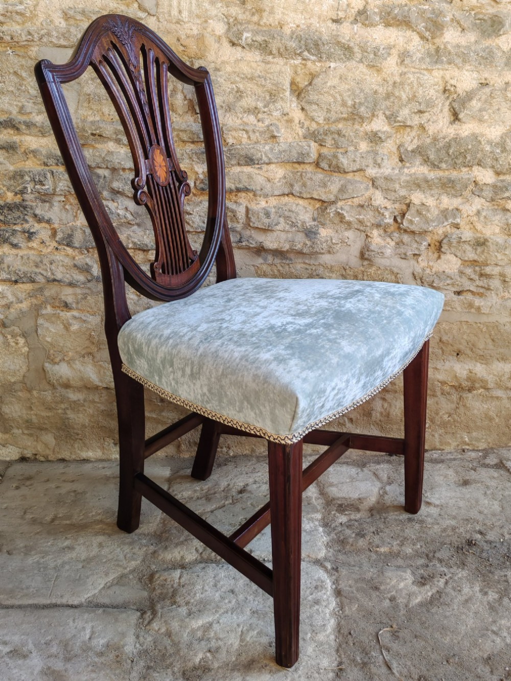 A set of four antique mahogany Hepplewhite dining chairs featuring carved shield-shaped backs with central inlay motifs and light green upholstered seats. View IX