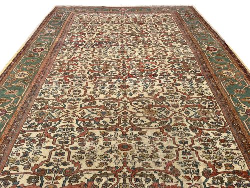 fig 2. An antique Persian Sultanabad wool carpet featuring a cream field with an intricate floral lattice motif and a wide teal green border.