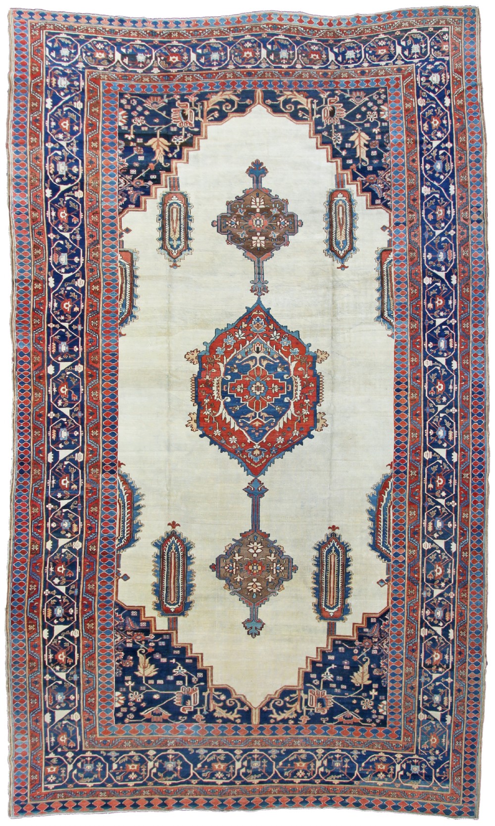 An antique Persian Bakshaish wool carpet featuring a central cream field with a red and blue geometric medallion, framed by dark blue spandrels and decorative borders.