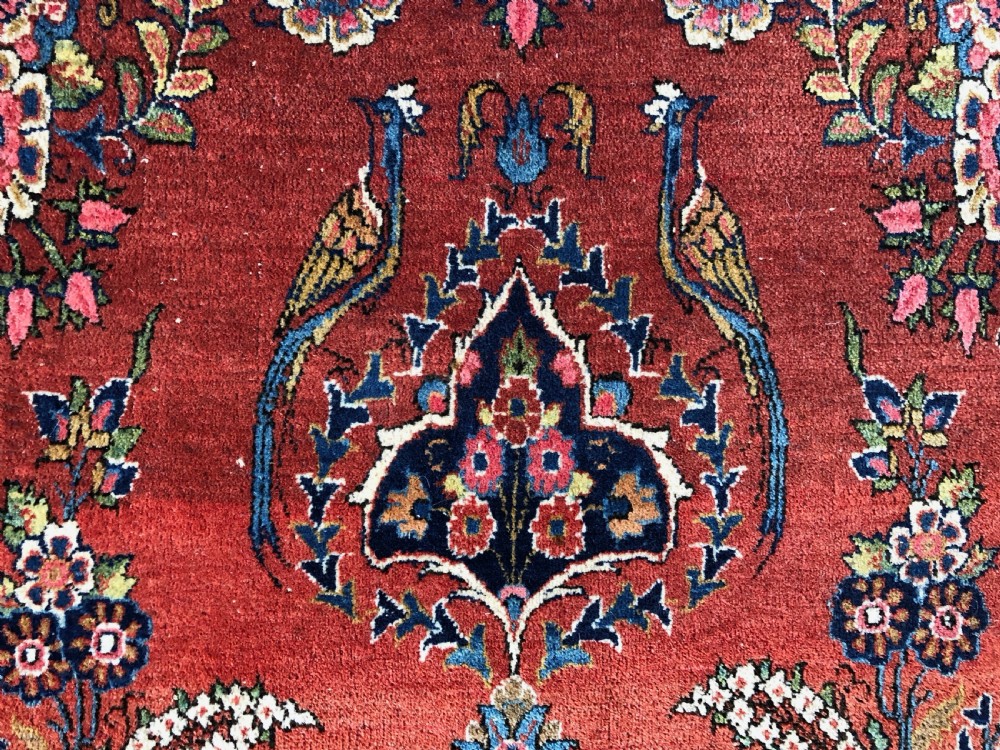 A pair of hand-knotted antique Persian Kashan rugs featuring crimson red fields decorated with floral urns and teardrop motifs within dark navy blue borders. View XV