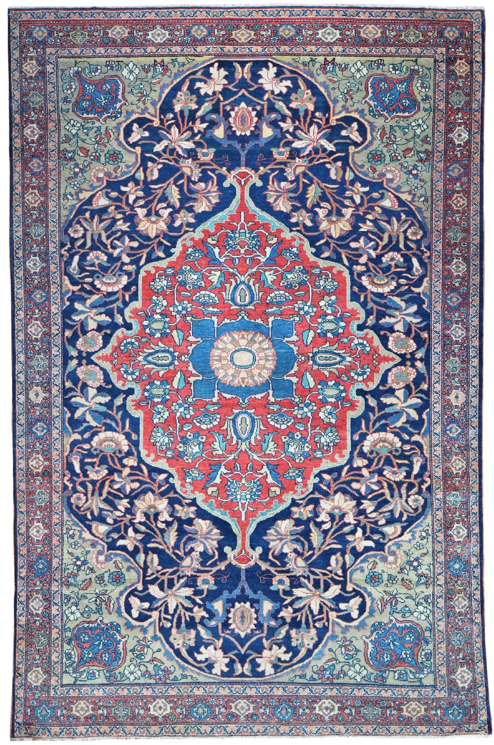 An antique hand-knotted Persian Farahan carpet featuring a central terracotta and light blue medallion set against a dark navy floral field with sage green spandrels.