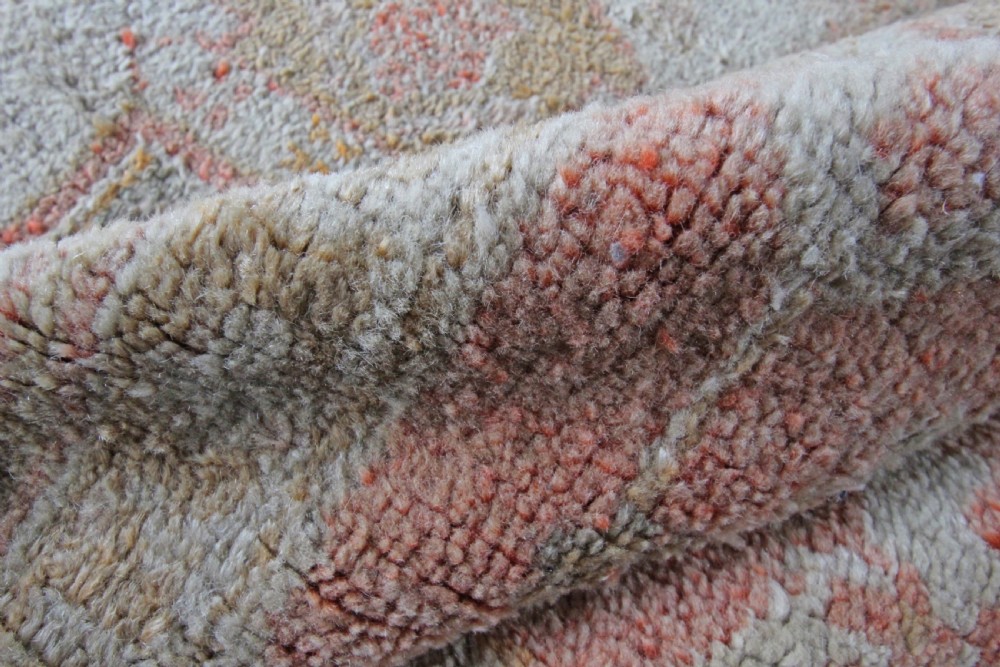 A late 19th-century hand-knotted Ushak wool carpet featuring soft terracotta borders surrounding a cream central field with muted botanical motifs. View II