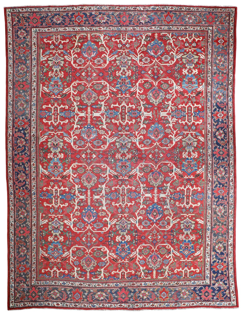 A hand-knotted antique Mahal carpet featuring an all-over floral lattice pattern on a red field surrounded by a navy blue patterned border.