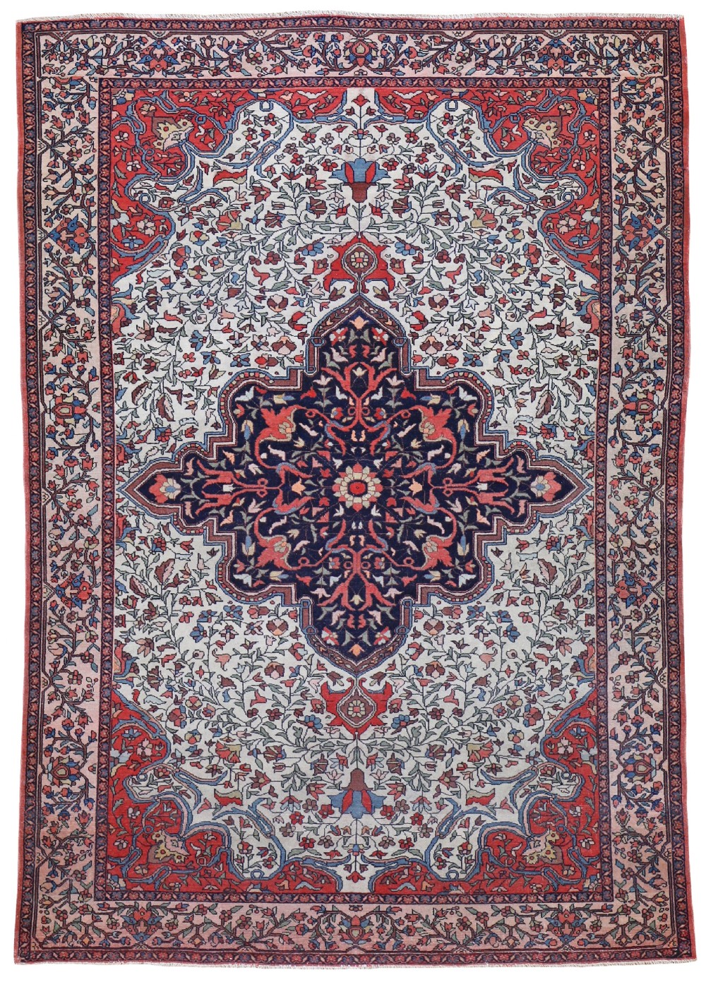 An antique Persian Malayer wool rug featuring a dark navy stepped central medallion surrounded by a floral ivory field, coral spandrels, and a patterned main border.