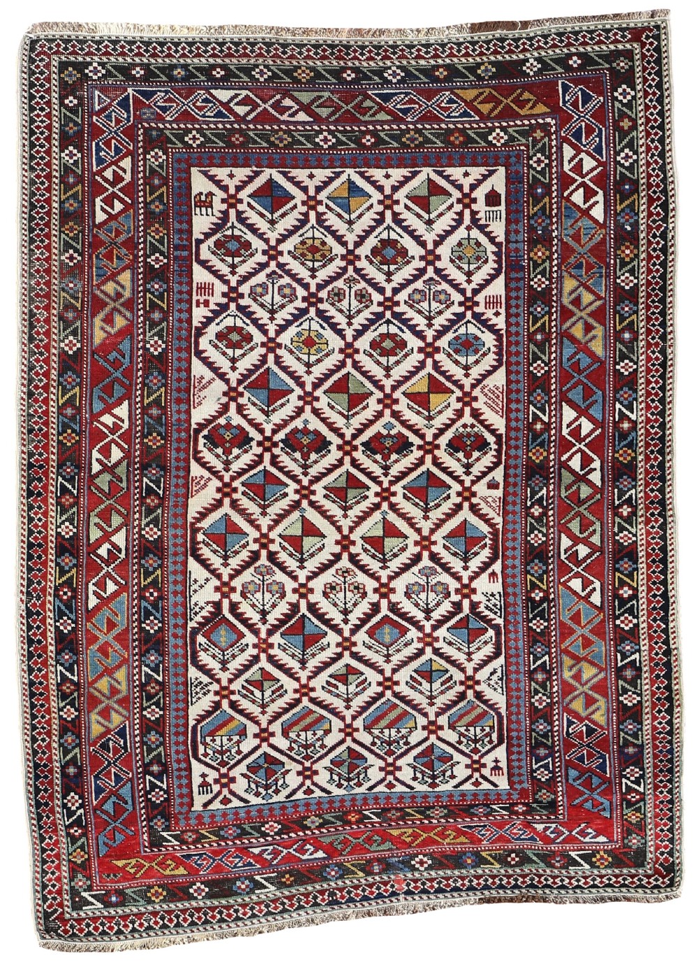 An antique Caucasian Shirvan hand-knotted wool rug featuring a central cream field with geometric diamond lattice motifs framed by multiple red and blue patterned borders.