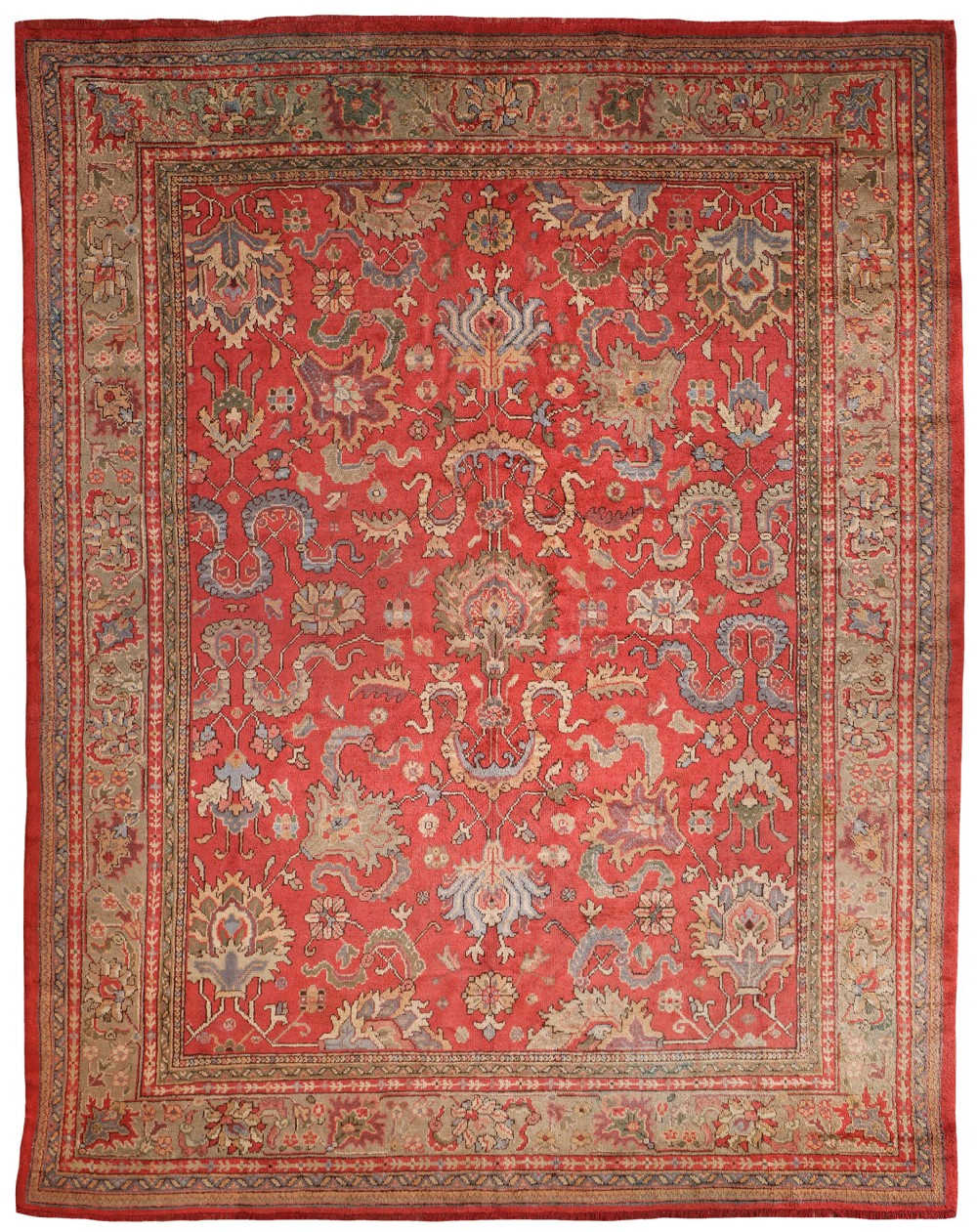 A hand-knotted antique Ushak wool carpet featuring a red central field filled with floral palmettes and a wide patterned border in grey and sage green.