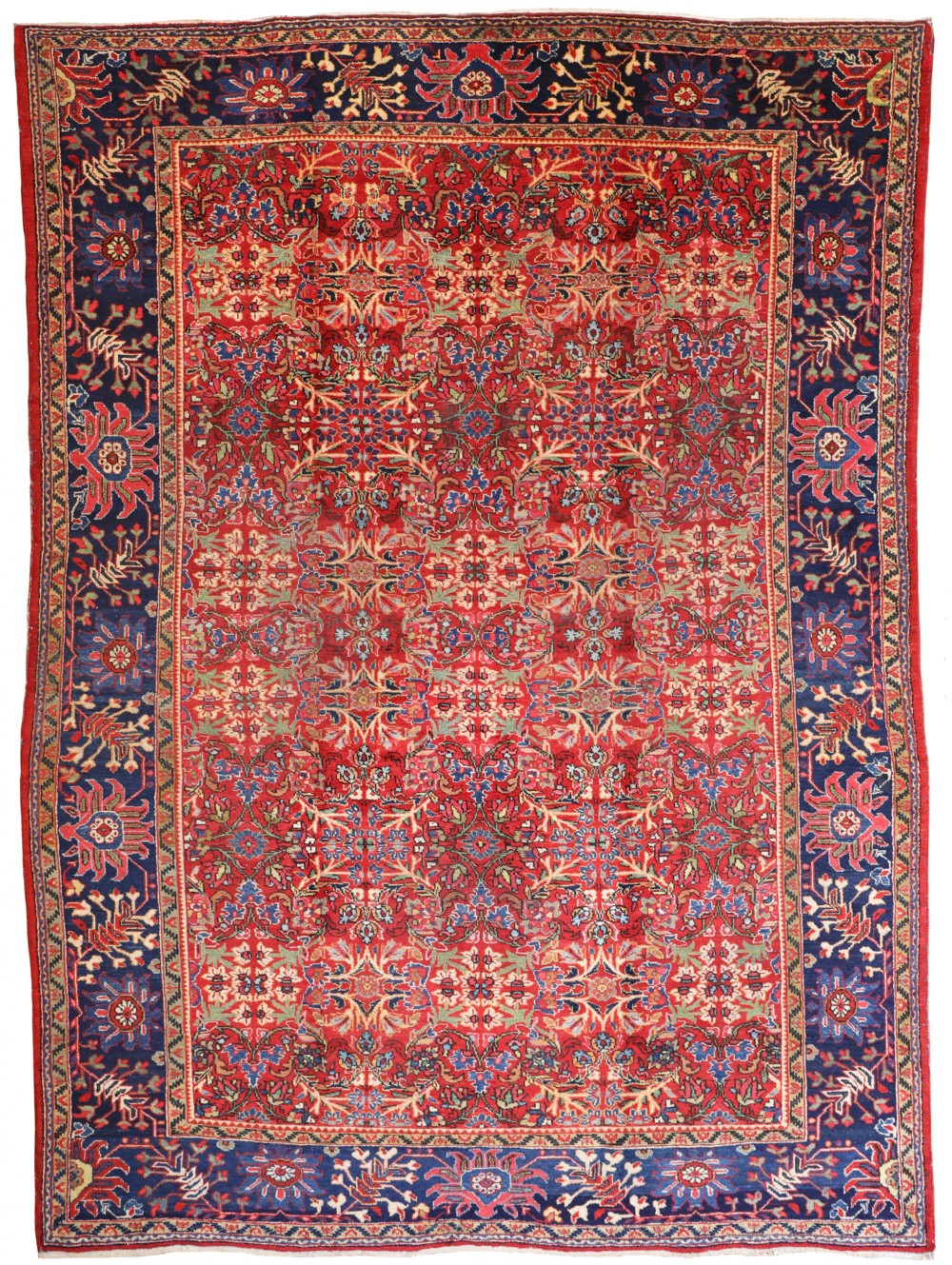 An antique hand-knotted wool Ziegler-Mahal carpet featuring an intricate floral lattice pattern across a deep red field bordered by a wide dark navy floral band.
