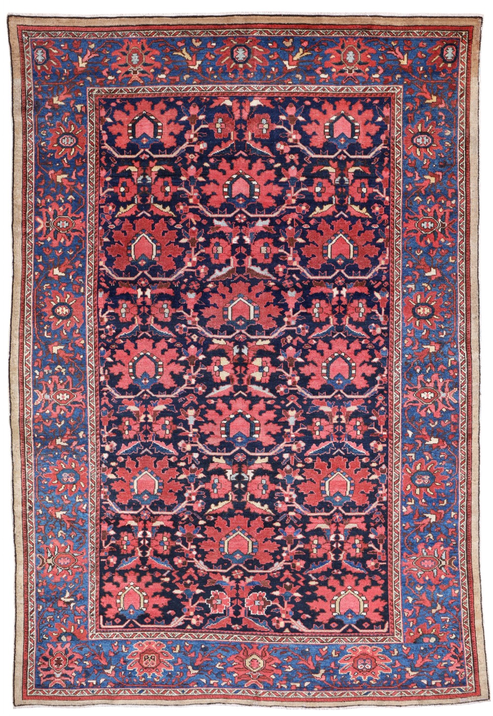 An antique Persian Malayer wool carpet featuring a dense navy blue center field with red geometric floral motifs and a detailed blue border.