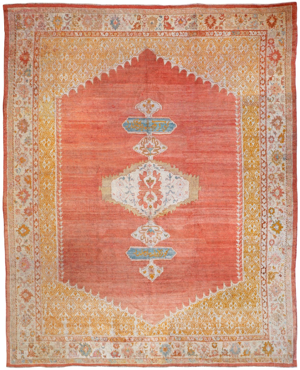An antique hand-knotted Angora Ushak carpet featuring a central medallion on a terracotta red field framed by stepped yellow spandrels and ornate floral borders.