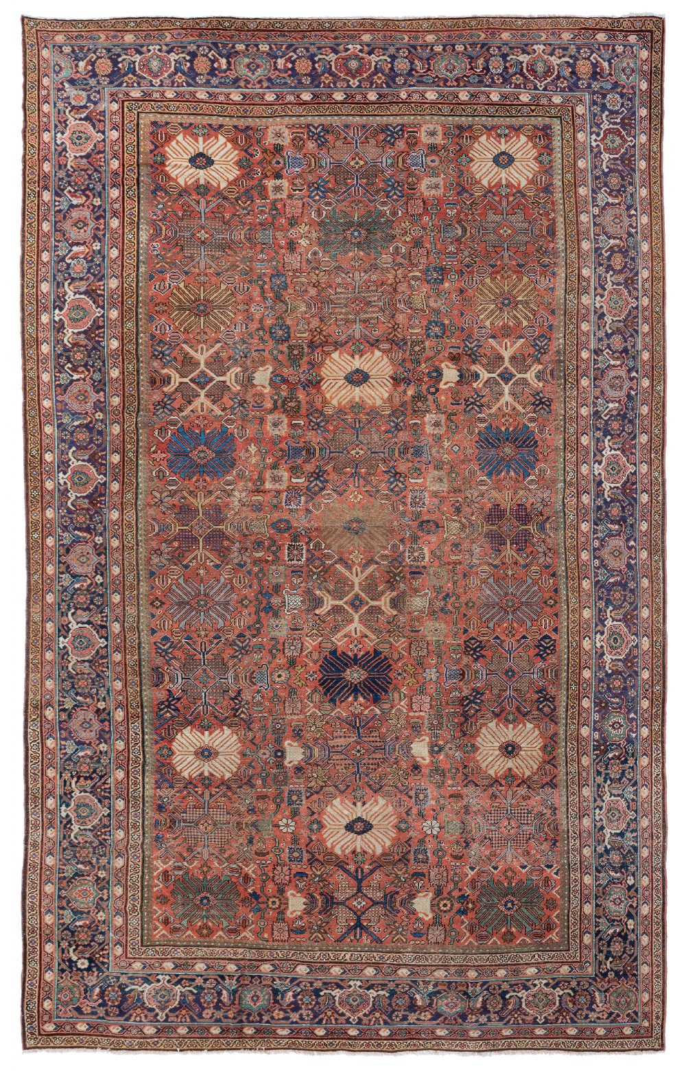 A large rectangular antique Persian Mahal wool carpet featuring a terracotta central field patterned with geometric and floral medallions, framed by a broad navy blue patterned border.
