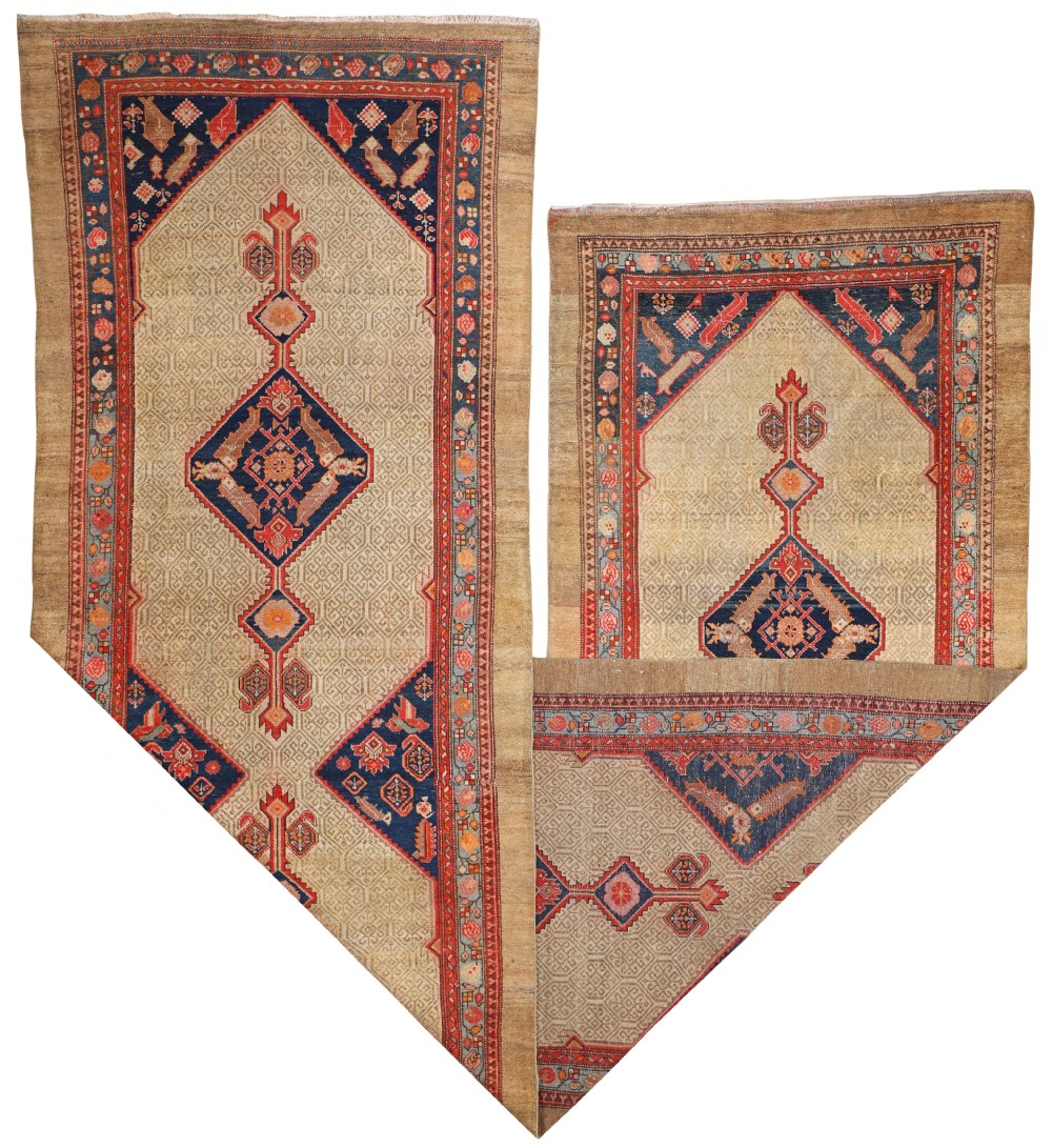 An antique Persian Sarab runner rug featuring a beige camel wool field detailed with blue and red geometric medallions.