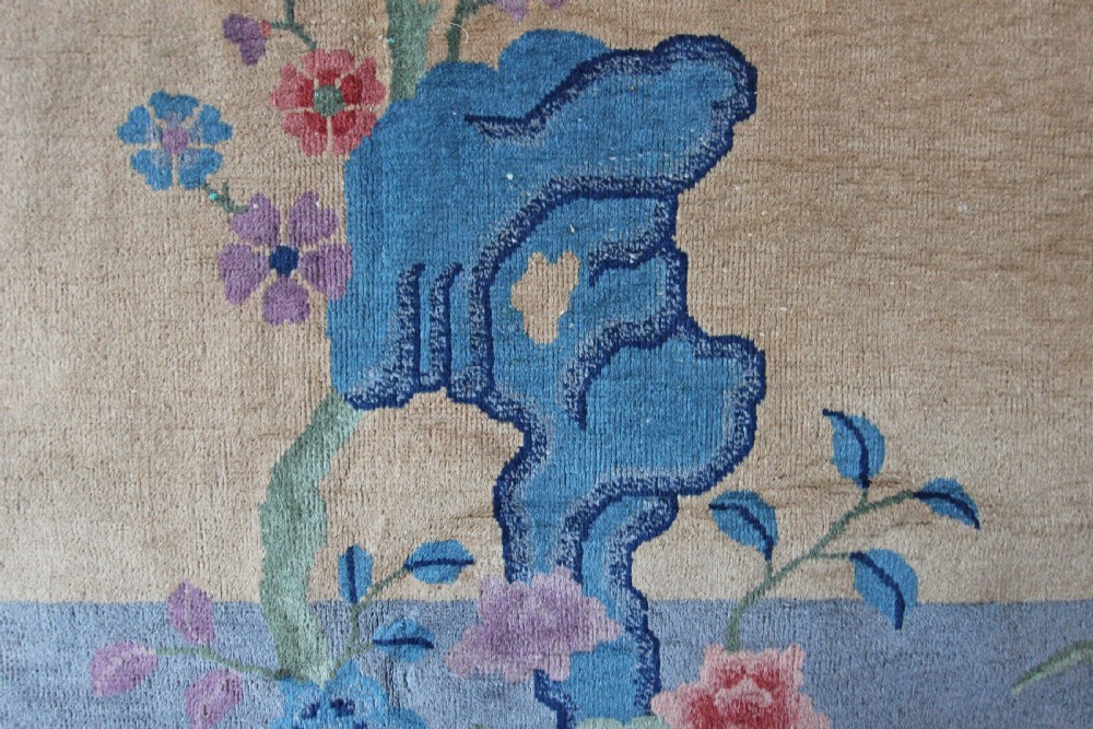 A rectangular Chinese Art Deco wool carpet featuring a beige central field bordered in periwinkle blue with asymmetrical floral and bird motifs. View II