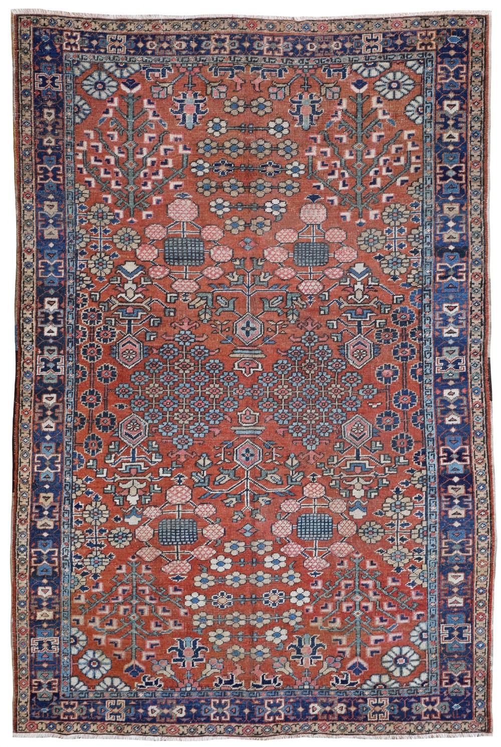 An antique hand-knotted Heriz carpet with geometric floral motifs across a terracotta red field and a blue border.