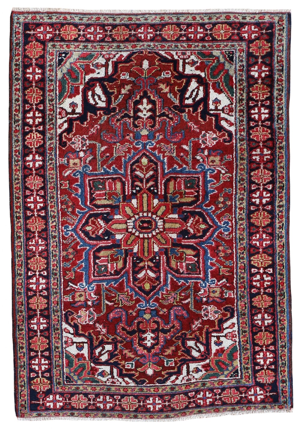 A hand-knotted antique Persian Heriz wool rug featuring a large central geometric medallion in red, blue, and ivory framed by a detailed multi-band border.