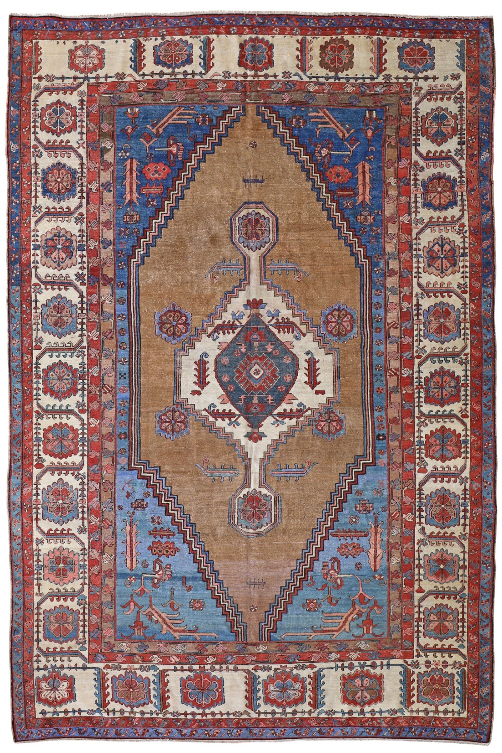 An antique Bakshaish hand-knotted wool carpet featuring a central geometric medallion surrounded by camel brown, blue, and terracotta tones with a broad patterned ivory border.