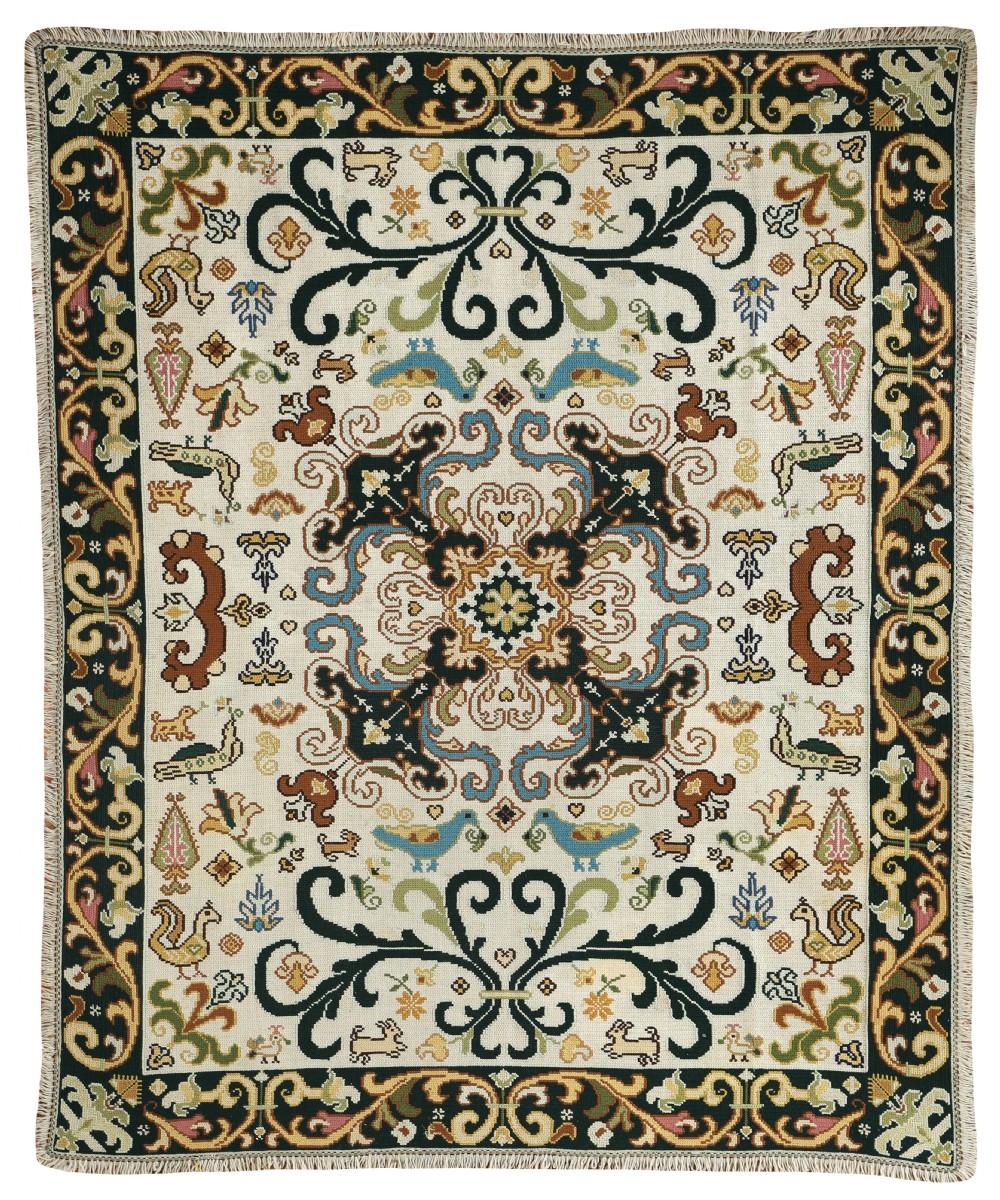 A rectangular handstitched Portuguese needlepoint rug featuring a cream central field with scrolling foliage, bird motifs, and a dark ornate border.