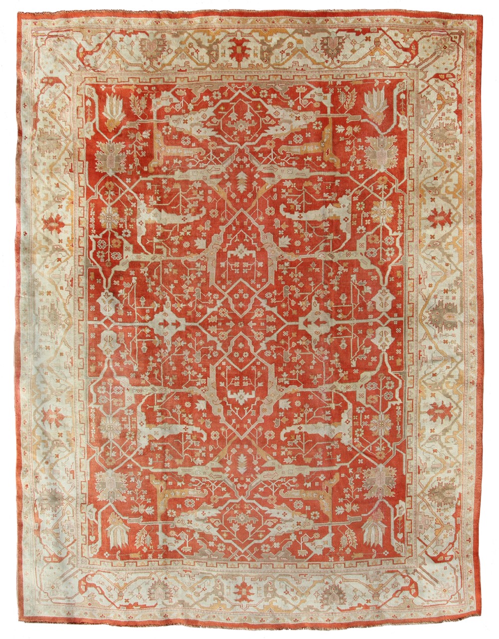 An antique hand-knotted wool Ushak carpet featuring a terracotta red field filled with cream geometric motifs and a matching patterned border.