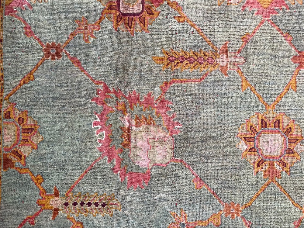 An antique hand-knotted wool Ushak carpet featuring a muted teal field with a lattice of floral palmettes surrounded by a wide terracotta border. View II