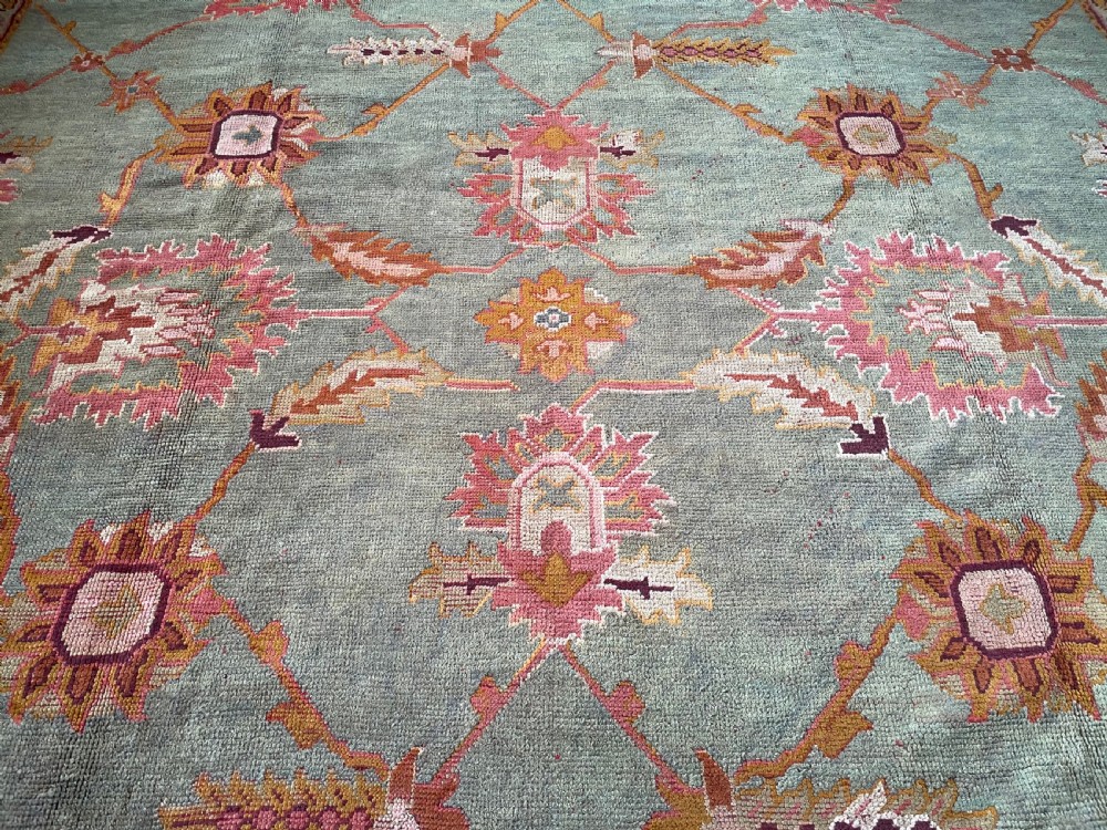 An antique hand-knotted wool Ushak carpet featuring a muted teal field with a lattice of floral palmettes surrounded by a wide terracotta border. View III