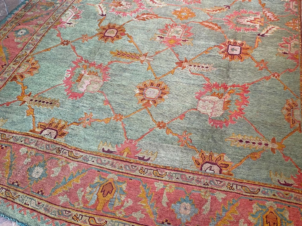 An antique hand-knotted wool Ushak carpet featuring a muted teal field with a lattice of floral palmettes surrounded by a wide terracotta border. View VI