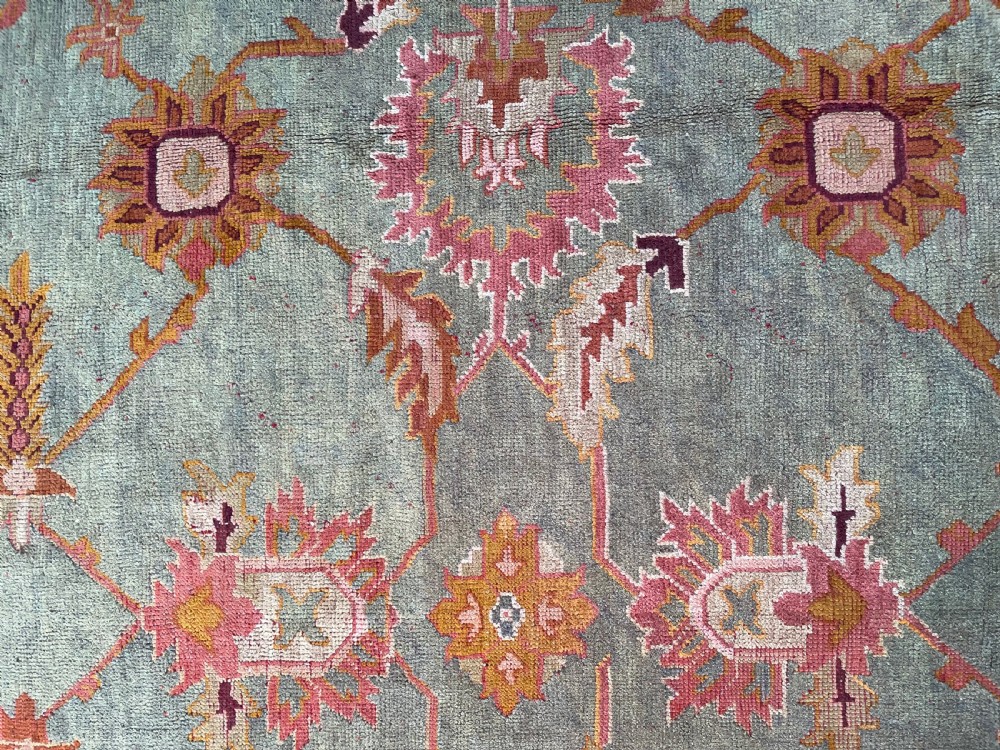An antique hand-knotted wool Ushak carpet featuring a muted teal field with a lattice of floral palmettes surrounded by a wide terracotta border. View VII
