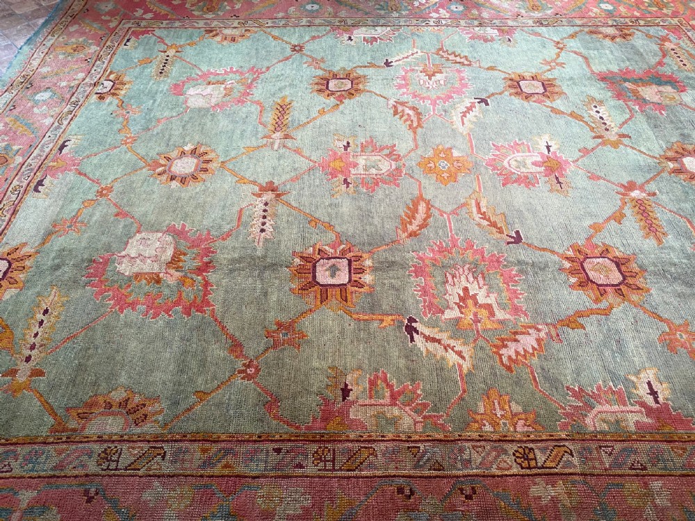An antique hand-knotted wool Ushak carpet featuring a muted teal field with a lattice of floral palmettes surrounded by a wide terracotta border. View VIII
