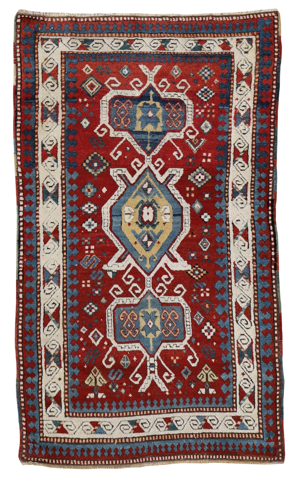 An antique hand-knotted Kazak wool rug featuring a central red field with layered geometric medallions in blue, ivory, and yellow, surrounded by a geometric border.