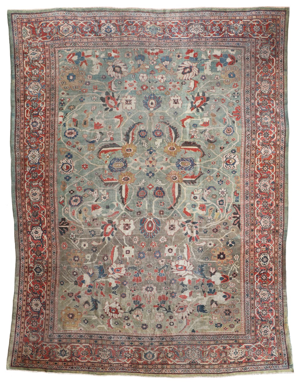 A hand-knotted antique Persian Ziegler carpet with a sage green central field of large floral palmettes surrounded by a rust red decorative border.