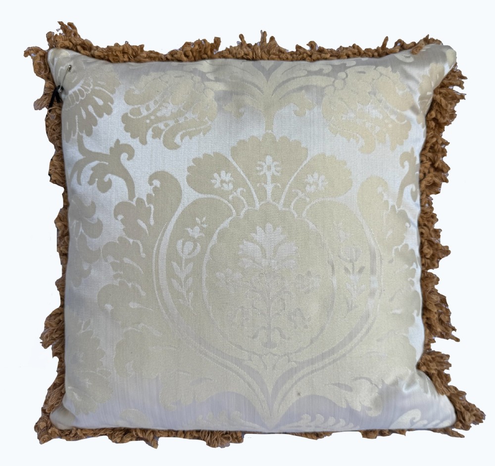 A square antique Aubusson tapestry cushion featuring scrolling floral motifs in muted green and pink on a cream background, finished with an ochre fringed border. View VII