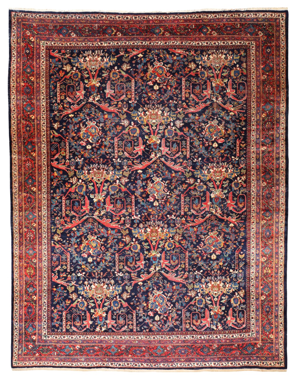 An antique Persian Mustafi Mahal wool carpet featuring a dark navy blue central field patterned with elaborate red and ochre floral scrollwork surrounded by a wide decorative border.