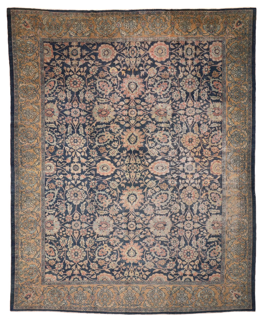 An antique Persian Mahal wool carpet featuring a deep navy blue field covered in intricate floral palmettes and a wide ochre border.