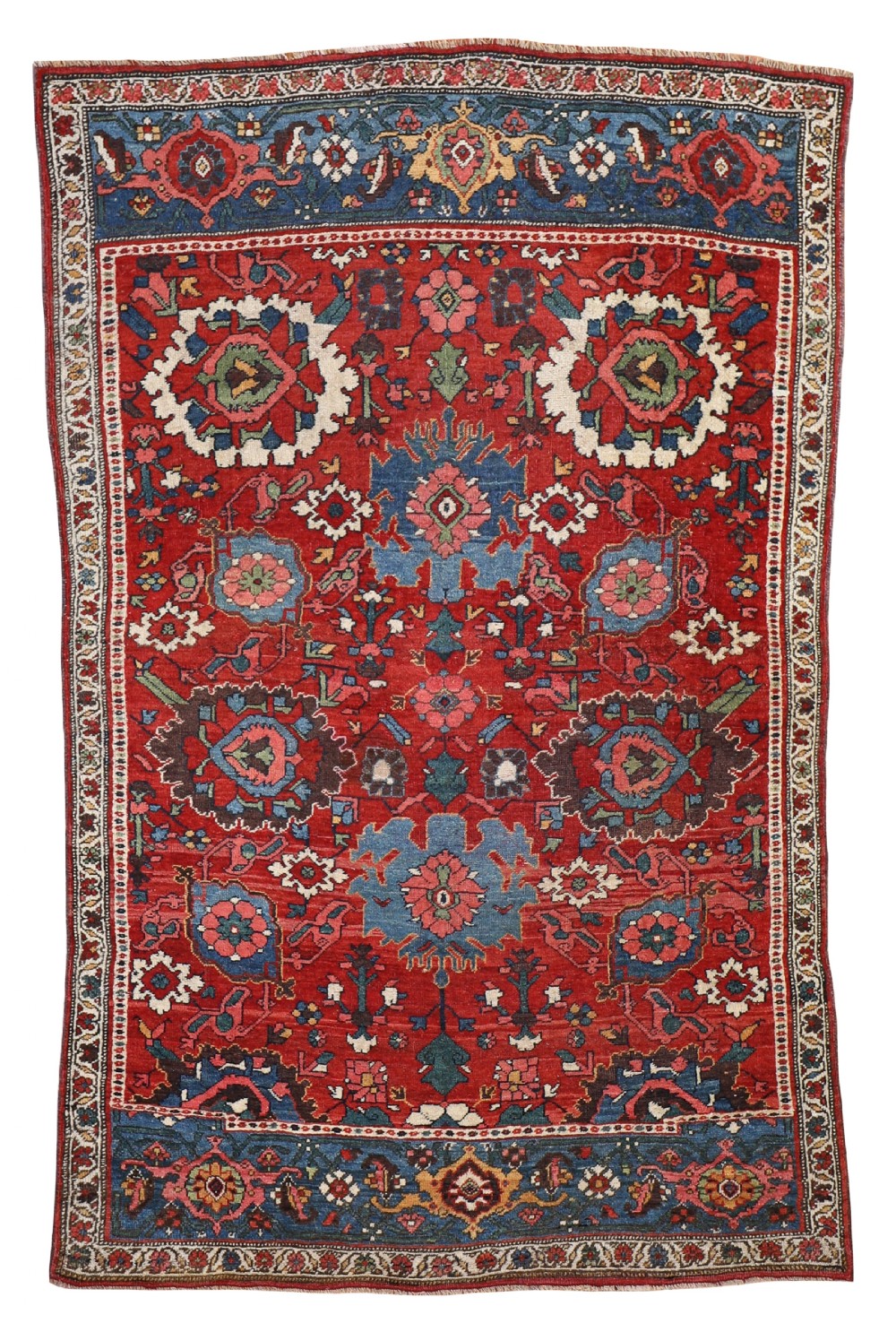 An antique hand-knotted Bidjar rug featuring a central red field filled with intricate floral motifs, bordered by indigo blue panels and geometric guard stripes.