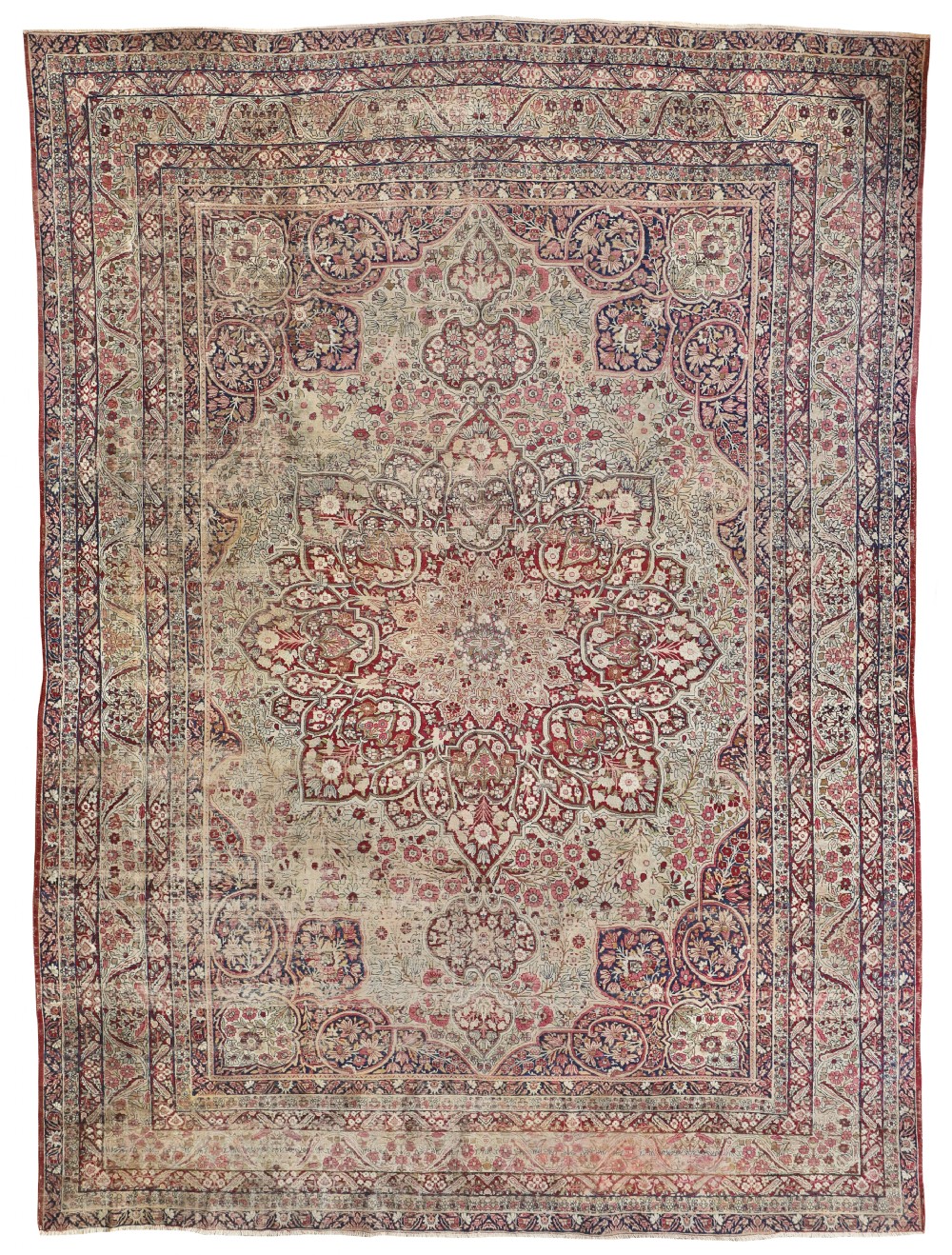 An antique hand-knotted Kirman carpet featuring an intricate central floral medallion, spandrels, multi-layered borders, and a distressed faded palette of red, cream, and navy.