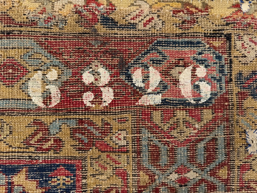 An elongated antique hand-knotted Caucasian Kuba Kelleh rug with a navy blue field featuring geometric repeating medallions framed by patterned multicoloured borders. View V