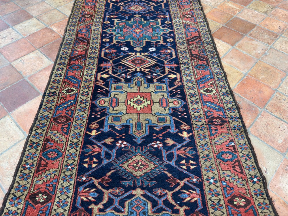 An antique Karaja hand-knotted wool runner featuring geometric blue and terracotta medallions on a dark navy field. View II