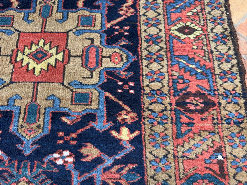 An antique Karaja hand-knotted wool runner featuring geometric blue and terracotta medallions on a dark navy field. View IV