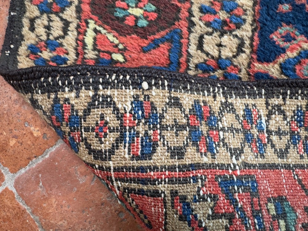 An antique Karaja hand-knotted wool runner featuring geometric blue and terracotta medallions on a dark navy field. View VIII