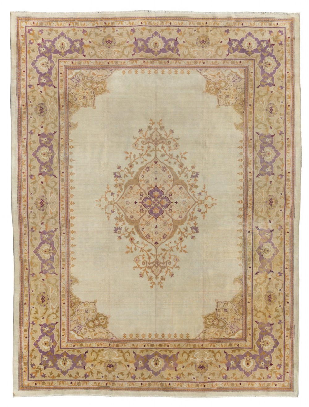 An antique hand-knotted rectangular wool carpet featuring a light cream field, a central floral medallion, corner spandrels, and a patterned border in shades of purple and ochre.