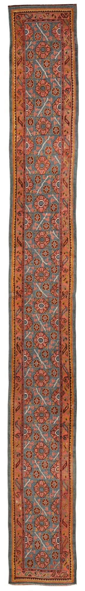 An exceptionally long antique Ushak runner rug displaying a central slate blue panel with repeating coral floral rosettes framed by a wide terracotta patterned border.