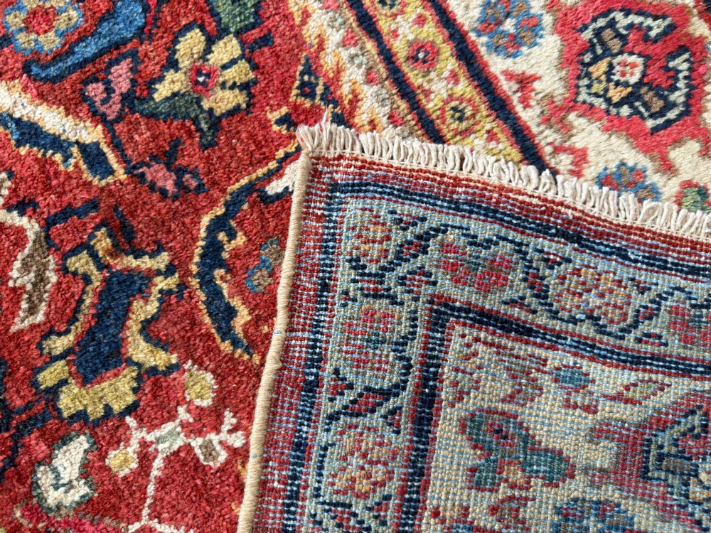 A hand-knotted antique Persian Mahal carpet featuring a terracotta red field with intricate floral motifs surrounded by cream and navy decorative borders. View III