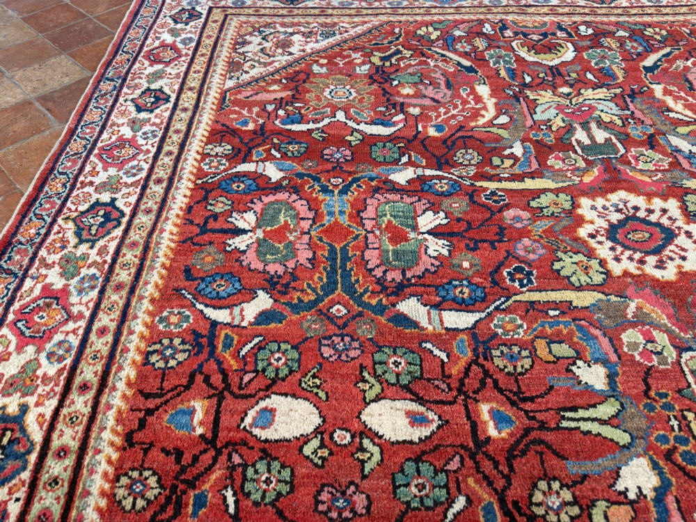 A hand-knotted antique Persian Mahal carpet featuring a terracotta red field with intricate floral motifs surrounded by cream and navy decorative borders. View VII