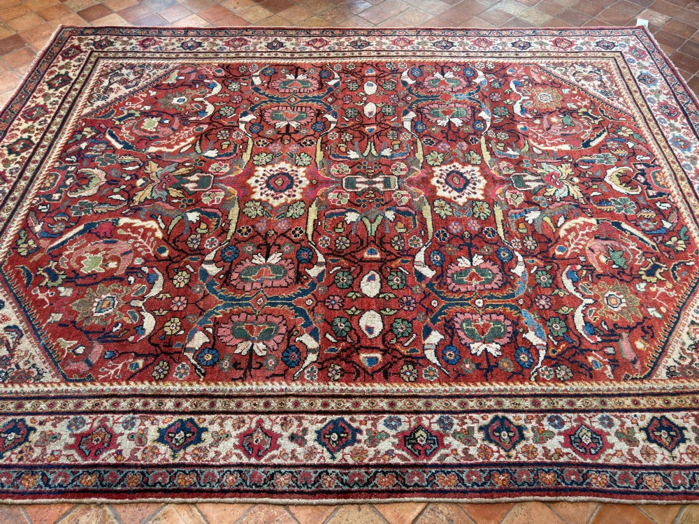 A hand-knotted antique Persian Mahal carpet featuring a terracotta red field with intricate floral motifs surrounded by cream and navy decorative borders. View VIII