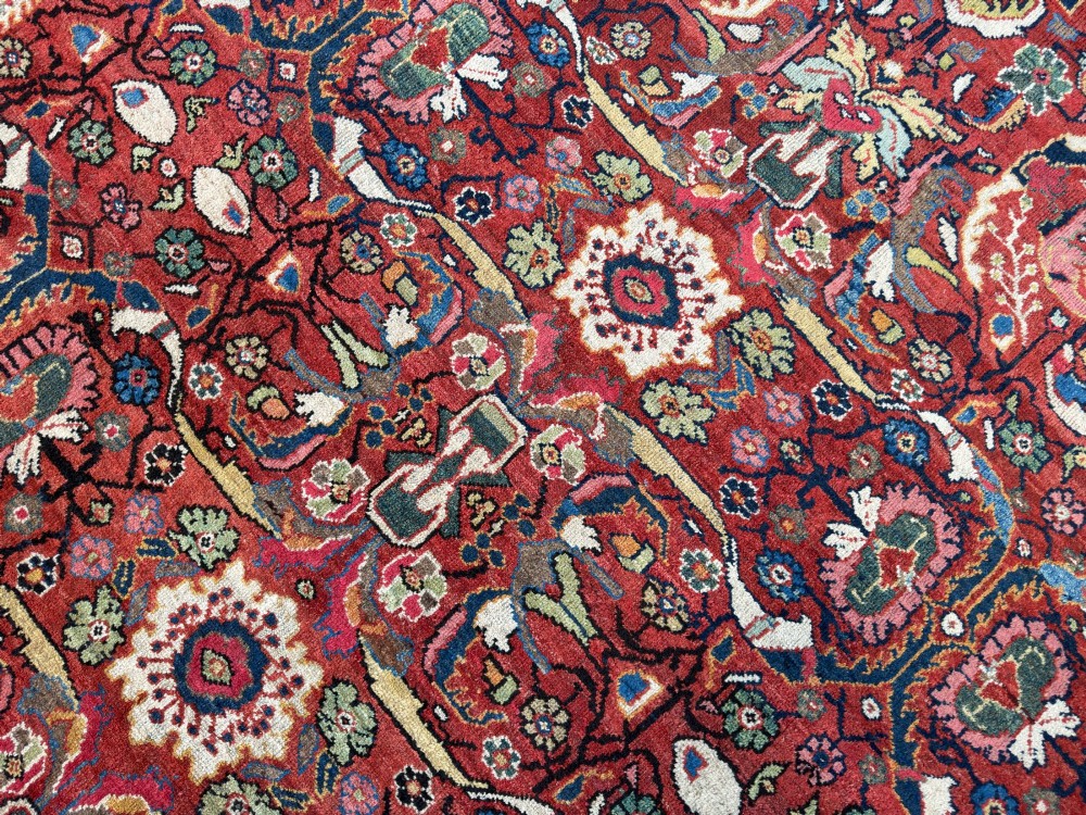 A hand-knotted antique Persian Mahal carpet featuring a terracotta red field with intricate floral motifs surrounded by cream and navy decorative borders. View IX