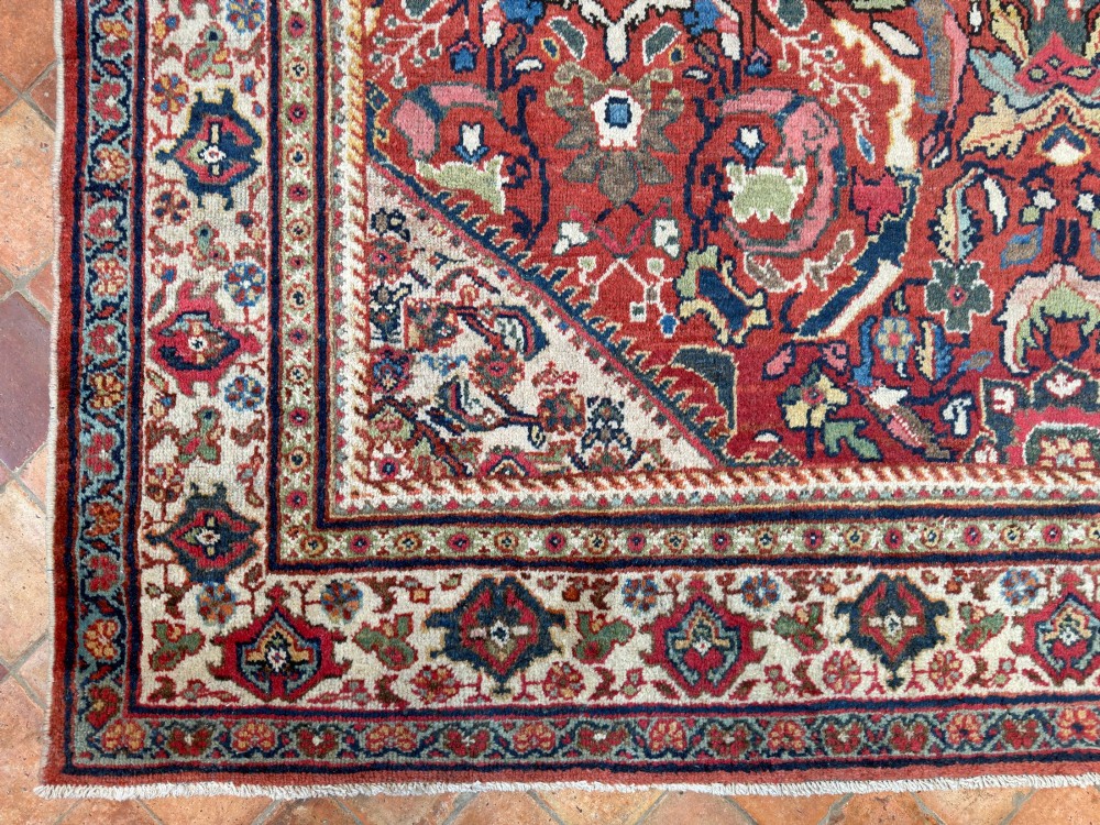 A hand-knotted antique Persian Mahal carpet featuring a terracotta red field with intricate floral motifs surrounded by cream and navy decorative borders. View XI