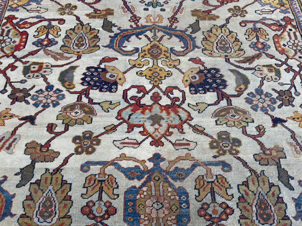 An antique hand-knotted Persian Mahal carpet featuring an ivory ground decorated with intricate floral vines and framed by a dark navy decorative border. View III